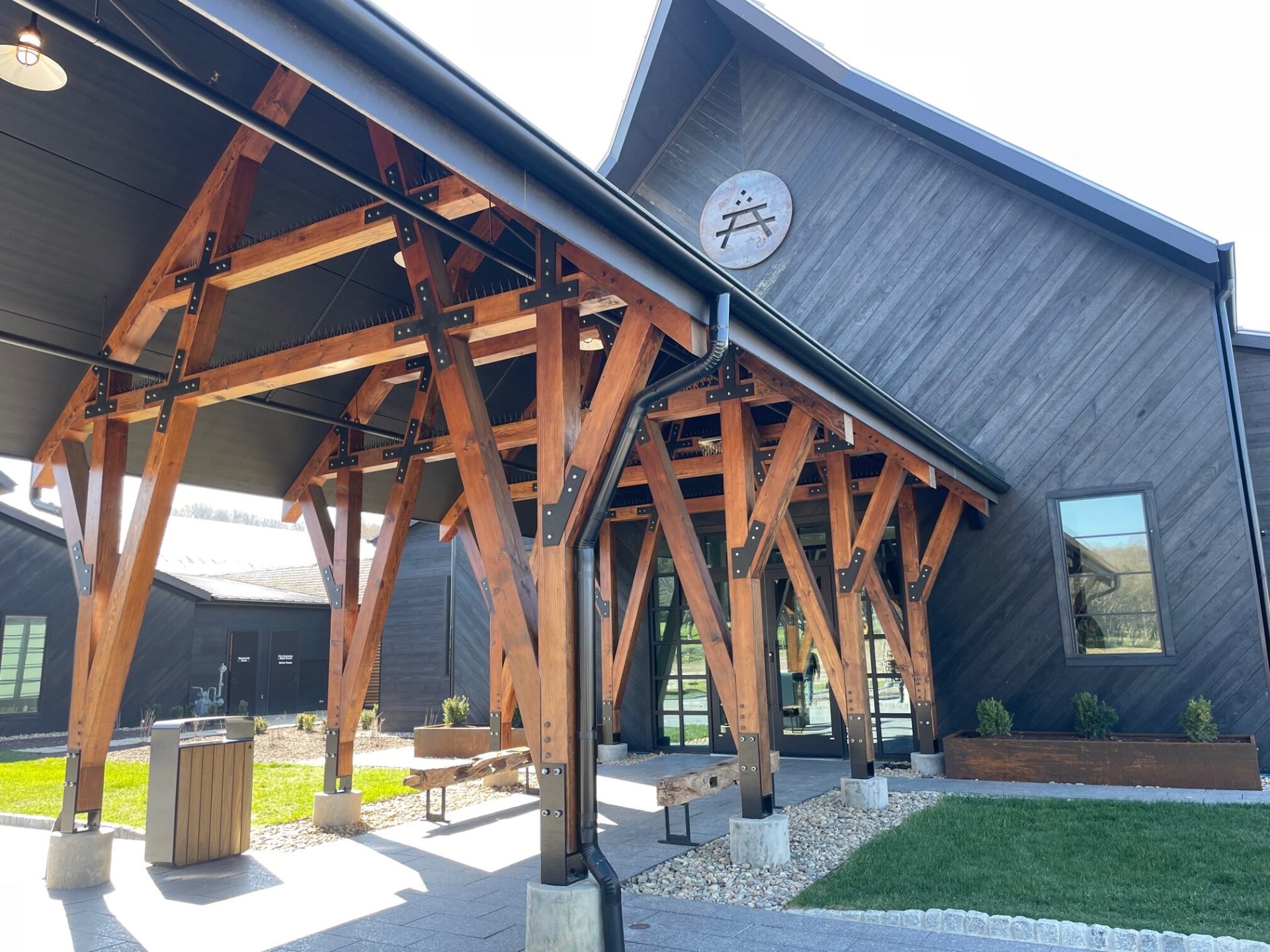 Heavy timber pavilion entry with steel-strapped trusses